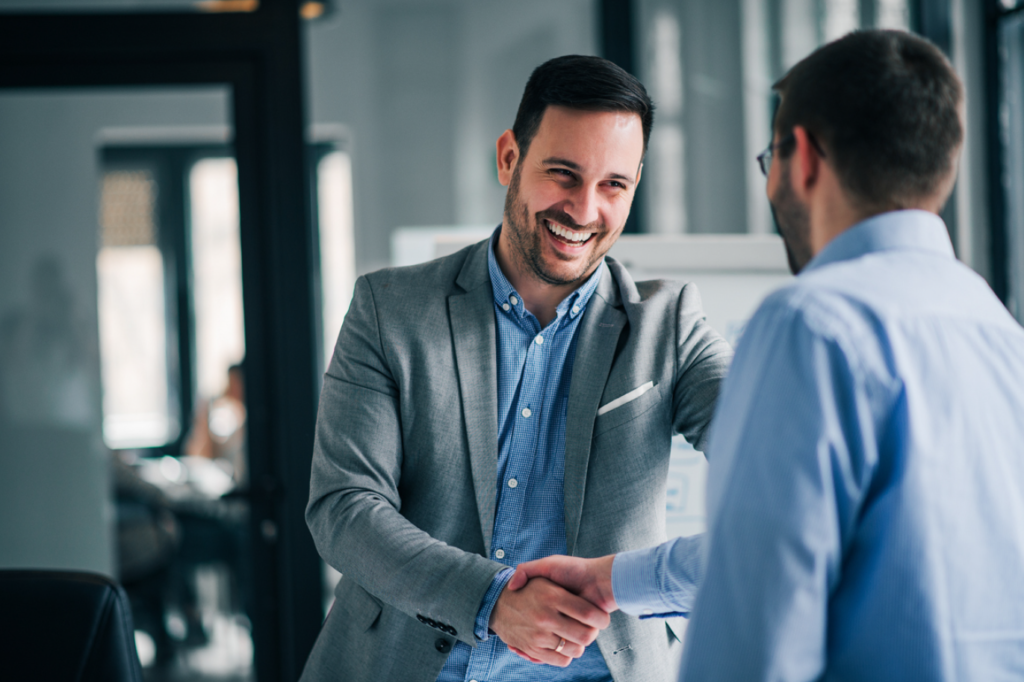 Distributeur agréé Optim'BTP, expert en solutions de gestion pour les professionnels du BTP serre la main d'un client satisfait